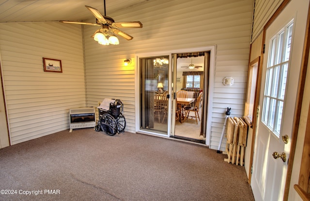 unfurnished sunroom with radiator, vaulted ceiling, heating unit, and ceiling fan