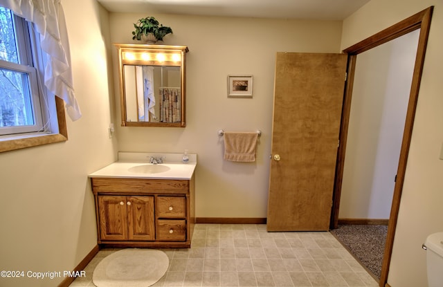 full bath featuring toilet, baseboards, and vanity