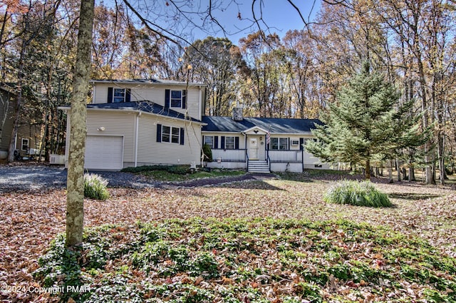 view of front of home featuring a garage, driveway, and a chimney