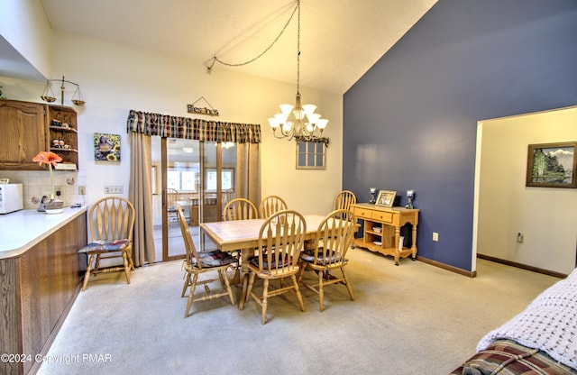 dining area with baseboards, high vaulted ceiling, an inviting chandelier, and light colored carpet