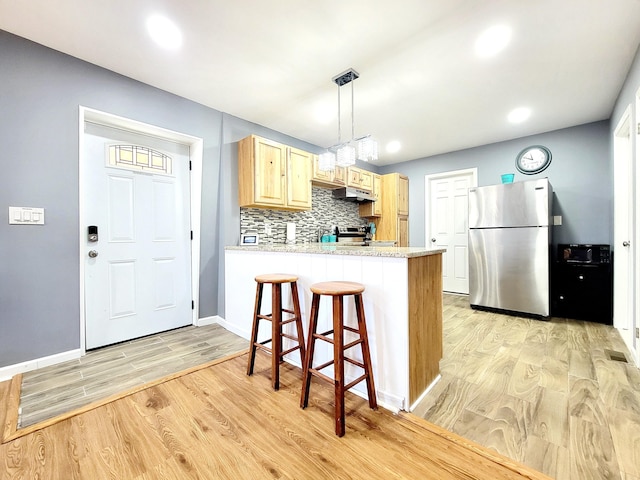 8237 Natures Dr, Tobyhanna, PA 18466 - kitchen featuring light wood finished floors, light countertops, decorative backsplash, a peninsula, and stainless steel appliances