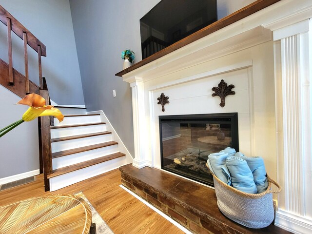 8237 Natures Dr, Tobyhanna, PA 18466 - staircase with a glass covered fireplace, visible vents, baseboards, and wood finished floors