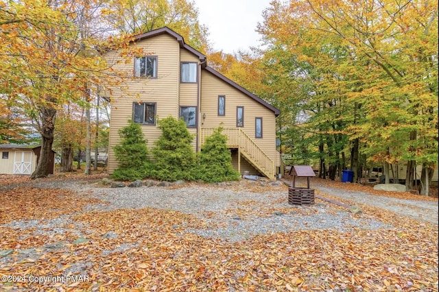 view of side of property with a shed, stairway, and an outdoor structure