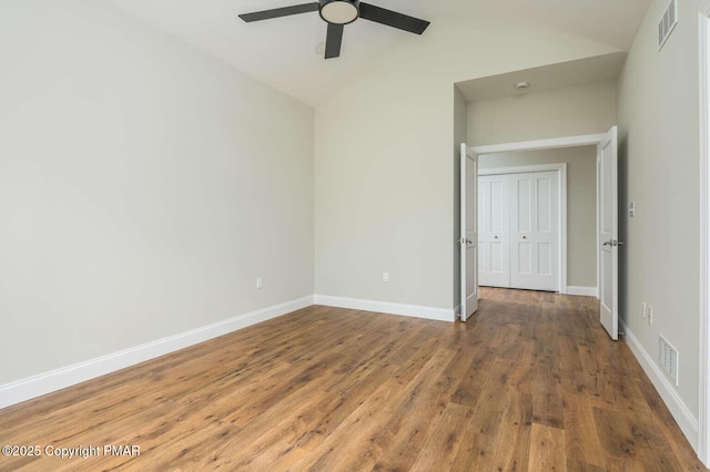 spare room with ceiling fan, lofted ceiling, and wood-type flooring