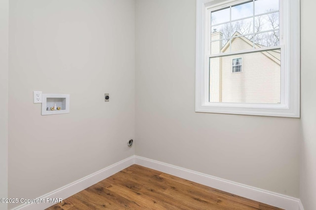 clothes washing area with wood-type flooring, hookup for an electric dryer, and hookup for a washing machine