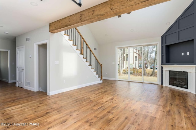 unfurnished living room with hardwood / wood-style flooring and lofted ceiling with beams