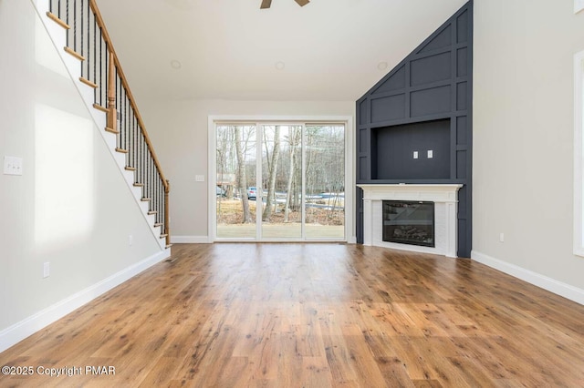 unfurnished living room with hardwood / wood-style flooring, ceiling fan, and high vaulted ceiling