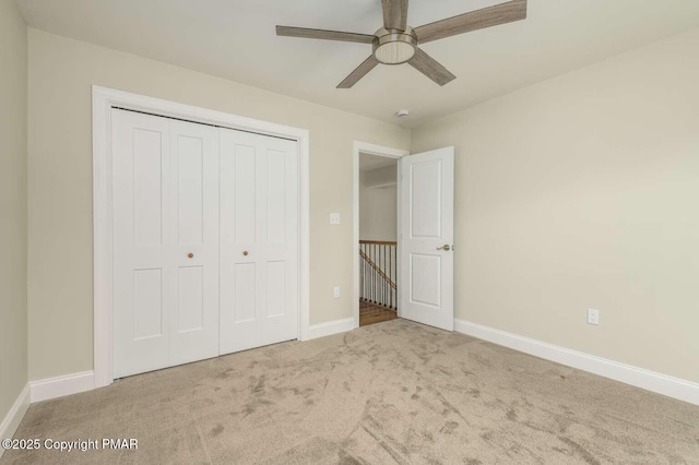 unfurnished bedroom with carpet flooring, ceiling fan, and a closet