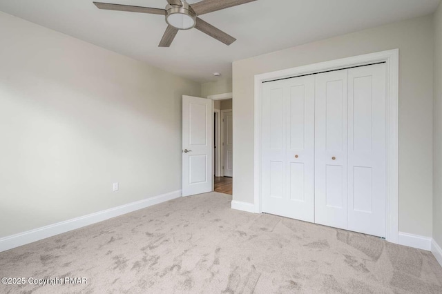 unfurnished bedroom with light colored carpet, a closet, and ceiling fan