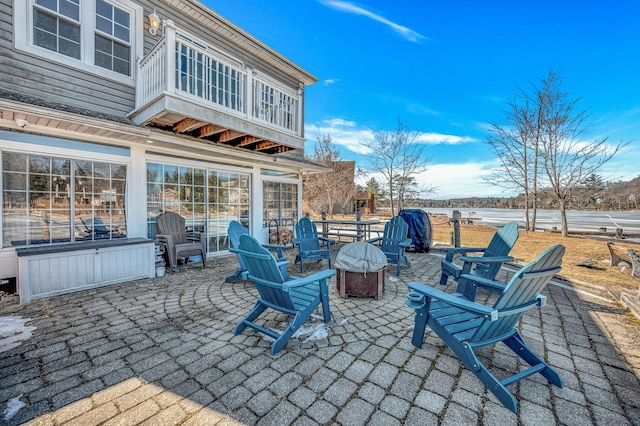 view of patio with a balcony and an outdoor fire pit