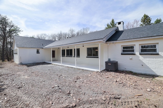 171 Knob Rd, Mount Pocono, PA 18344 - back of property with central air condition unit, a patio, a shingled roof, and a chimney