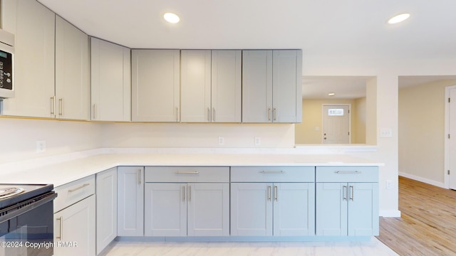 kitchen with light wood-style floors, recessed lighting, gray cabinets, and light countertops