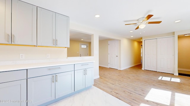 kitchen with light wood-type flooring, baseboards, light countertops, and recessed lighting