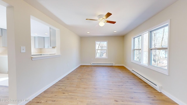 spare room with light wood-style floors, a baseboard radiator, baseboards, and recessed lighting