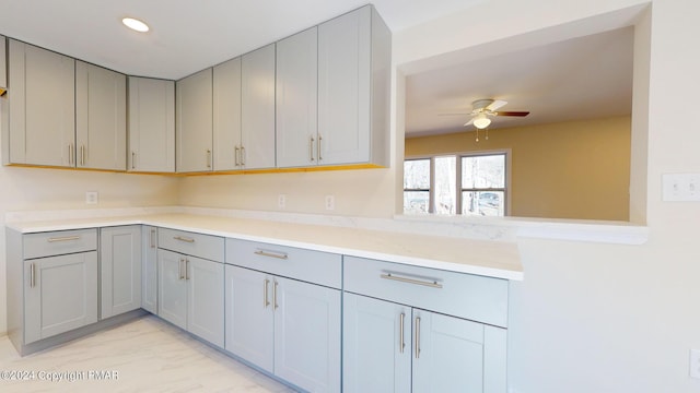 kitchen with ceiling fan, recessed lighting, marble finish floor, light countertops, and gray cabinets