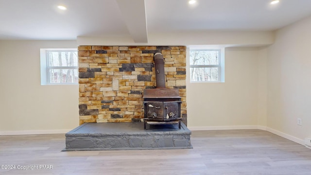 details with wood finished floors, a wood stove, and baseboards