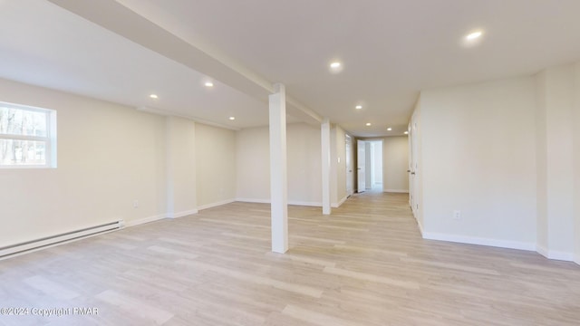 basement featuring light wood-style flooring, baseboards, baseboard heating, and recessed lighting