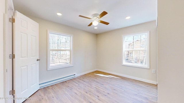 unfurnished room with light wood-type flooring, baseboard heating, plenty of natural light, and recessed lighting