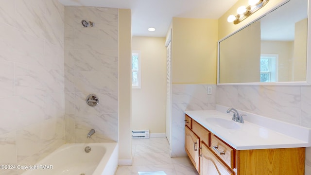 bathroom with marble finish floor, bathing tub / shower combination, vanity, and tile walls