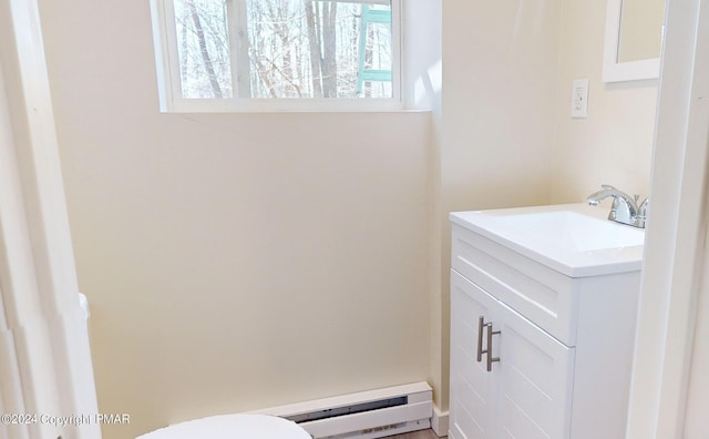 bathroom featuring a baseboard heating unit, toilet, and vanity