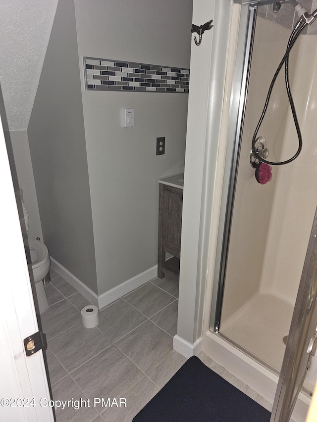 full bathroom with tile patterned floors, toilet, baseboards, and a stall shower