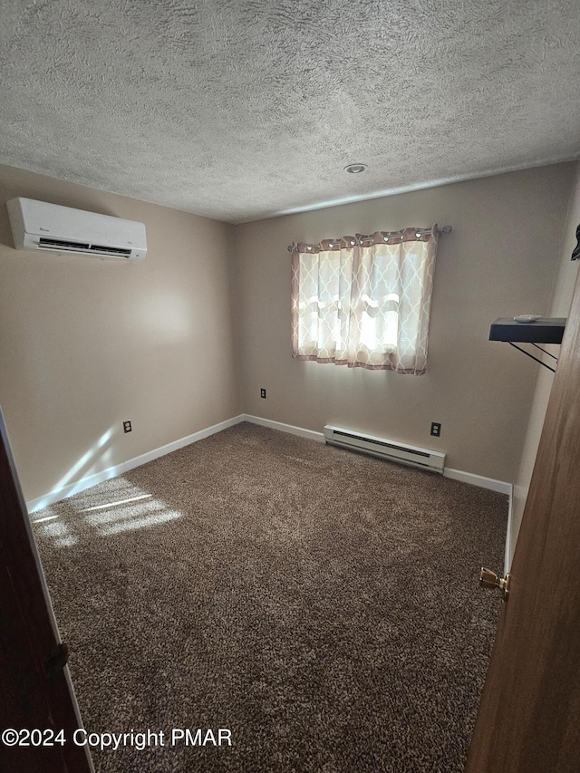 carpeted spare room with a baseboard radiator, baseboards, a textured ceiling, and a wall unit AC