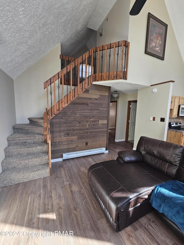 living area featuring stairway, wood finished floors, and a textured ceiling