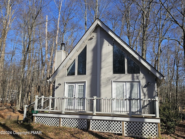 exterior space with a wooden deck and a chimney