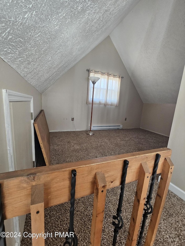 additional living space with carpet floors, baseboard heating, vaulted ceiling, and a textured ceiling