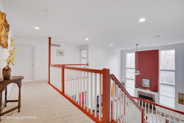 hall featuring carpet, an upstairs landing, visible vents, and recessed lighting