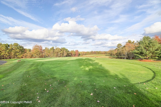 view of home's community featuring a lawn and golf course view