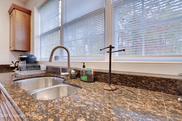 room details featuring dark stone countertops and a sink