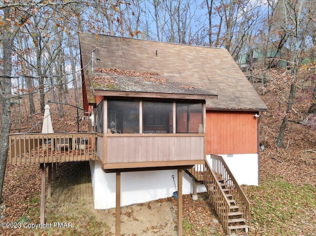 back of property featuring a sunroom, stairs, and a wooden deck