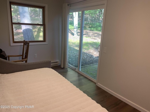 bedroom featuring a baseboard radiator, access to outside, baseboards, and dark wood finished floors