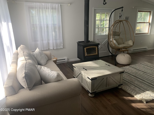 living room featuring plenty of natural light, dark wood-style flooring, a baseboard radiator, and a wood stove