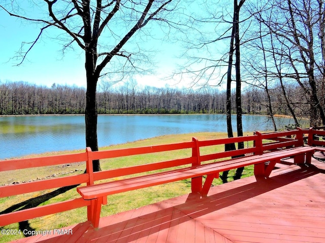 wooden terrace with a view of trees and a water view