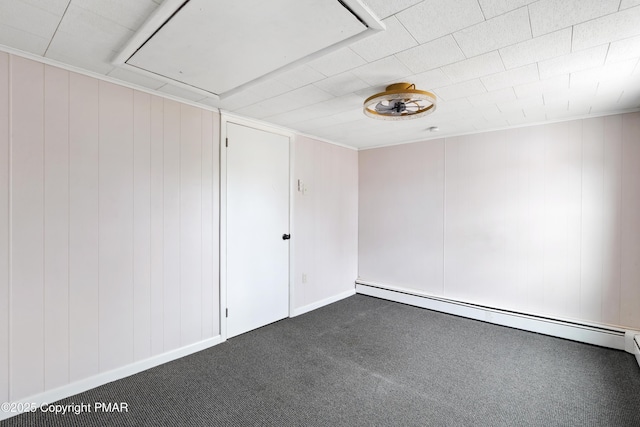 unfurnished room with dark colored carpet, baseboard heating, and attic access