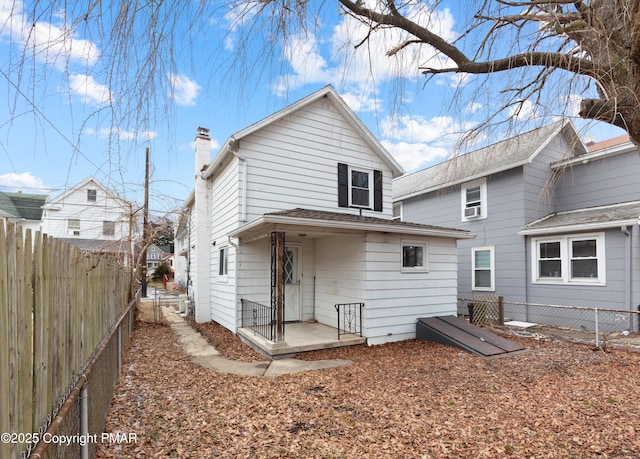 rear view of house featuring a fenced backyard and a chimney