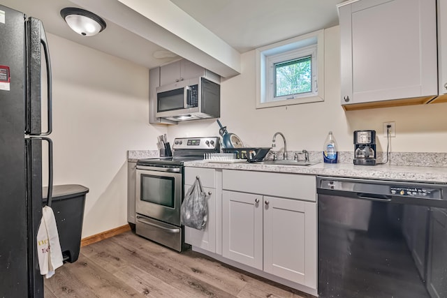217 Coach Rd, Tobyhanna, PA 18466 - kitchen with black appliances, light wood-type flooring, a sink, light countertops, and baseboards