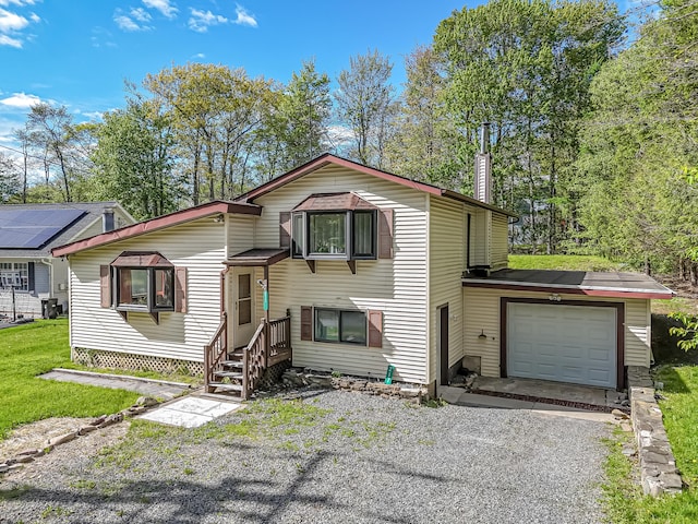 217 Coach Rd, Tobyhanna, PA 18466 - split level home with driveway, a chimney, and an attached garage