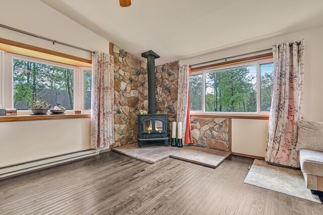 217 Coach Rd, Tobyhanna, PA 18466 - unfurnished living room featuring a wood stove, hardwood / wood-style floors, lofted ceiling, baseboard heating, and baseboards