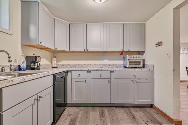 217 Coach Rd, Tobyhanna, PA 18466 - kitchen with black dishwasher, light wood-type flooring, light countertops, a sink, and gray cabinetry