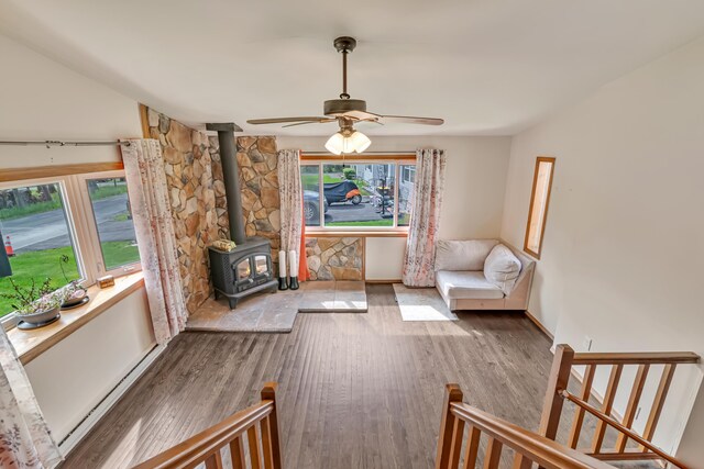 217 Coach Rd, Tobyhanna, PA 18466 - living area with a wood stove, wood finished floors, ceiling fan, and baseboard heating