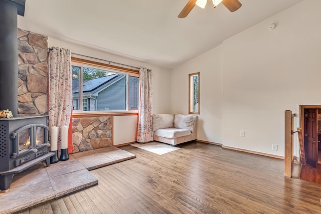 217 Coach Rd, Tobyhanna, PA 18466 - unfurnished room featuring a wood stove, lofted ceiling, wood finished floors, a ceiling fan, and baseboards