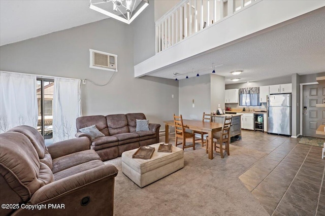 living area featuring a high ceiling, visible vents, and a textured ceiling