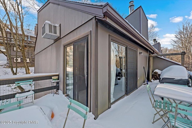 snow covered property with a chimney