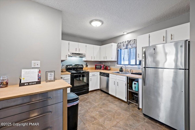 kitchen with a textured ceiling, stainless steel appliances, a sink, white cabinets, and light countertops