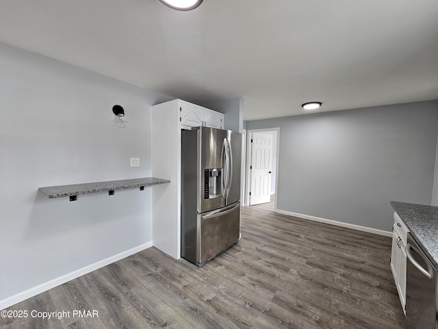 kitchen featuring stainless steel appliances, white cabinetry, baseboards, and wood finished floors