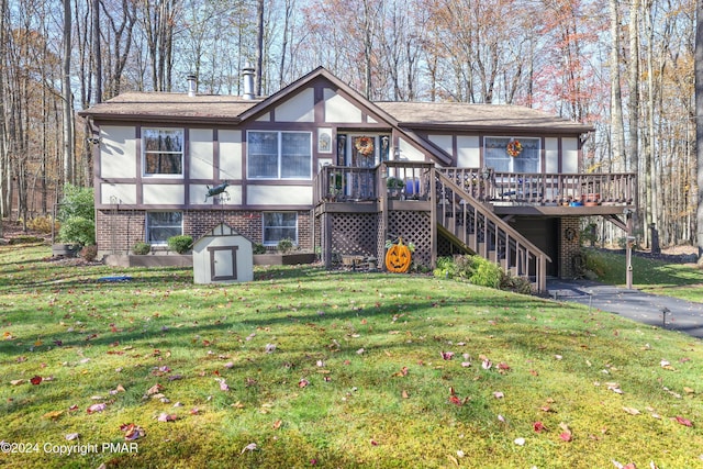 rear view of property featuring driveway, brick siding, stairs, a yard, and stucco siding