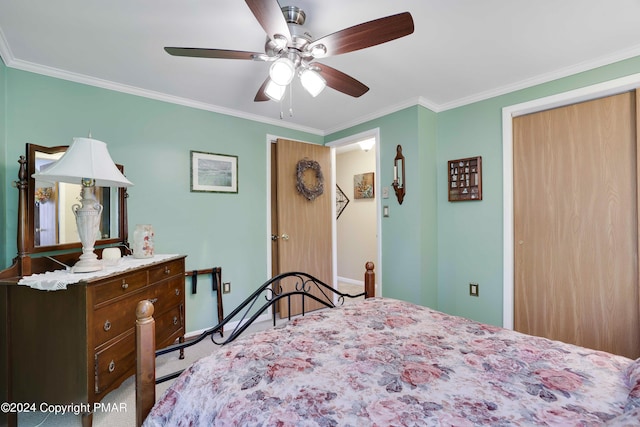 carpeted bedroom with a closet, crown molding, baseboards, and ceiling fan